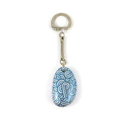 Porte-clé petit galet peint aux volutes bleues roi métallisées sur fond blanc