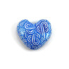 Magnet réalisé avec un faux galet en forme de cœur peint blanc aux volutes bleues métallisées
