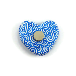 Magnet réalisé avec un faux galet en forme de cœur peint blanc aux volutes bleues métallisées