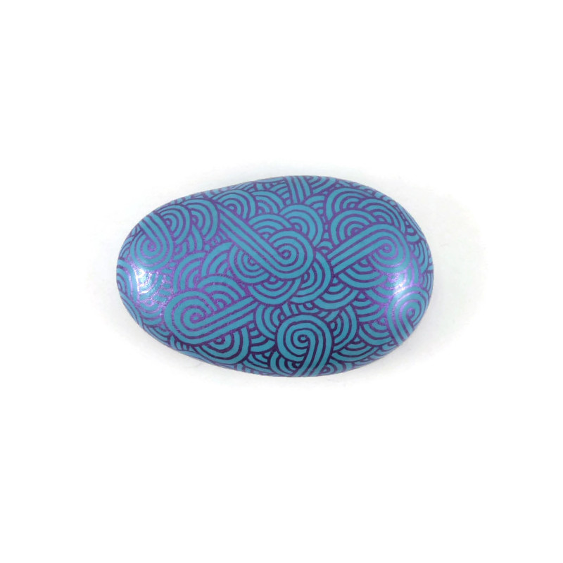 Painted pebble with metallic purple doodles on blue background