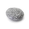 Painted pebble with black doodles on white background