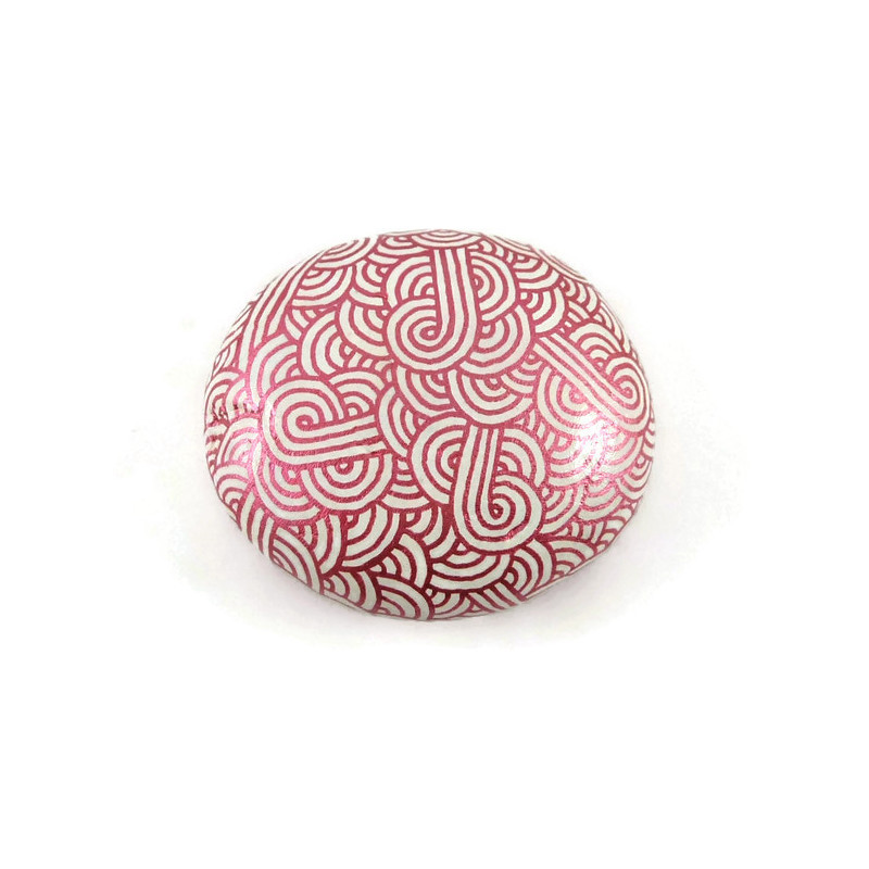 Painted pebble with metallic fushia pink doodles on white background