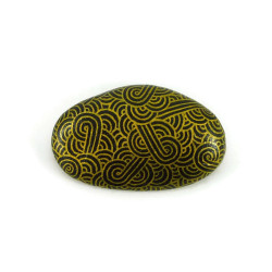 Painted pebble with golden doodles on black background