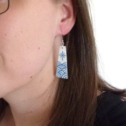 White trapezoid dangle earrings with metallic royal blue sun and waves
