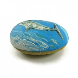 Galet peint représentant un dauphin nageant dans la mer