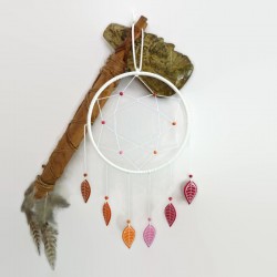 White dreamcatcher with leaves in the colors of the lesbian flag