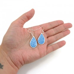 Boucles d'oreilles pendantes en forme de petites gouttes blanches aux volutes bleues métallisées
