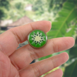 Eco-friendly green kiwi slice pin badge, made with hand-painted recycled CD