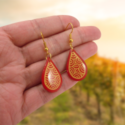 Red droplets dangle earrings with yellow doodles