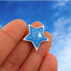 Magnet éco-responsable en forme d'étoile blanche aux volutes bleues métallisées