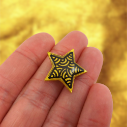 Magnet éco-responsable en forme d'étoile dorée aux volutes noires