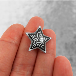 Magnet éco-responsable en forme d'étoile argentée aux volutes noires