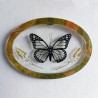 Cadre ovale avec faux papillon féerique transparent et noir pailleté, et fleurs et feuilles séchées