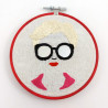 Broderie d'un visage de femme à lunettes