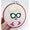 Broderie d'un visage de femme à lunettes