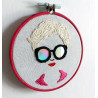 Broderie d'un visage de femme à lunettes