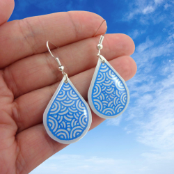 Boucles d'oreilles pendantes en forme de gouttes blanches aux volutes bleues métallisées (Vendues à l'unité)